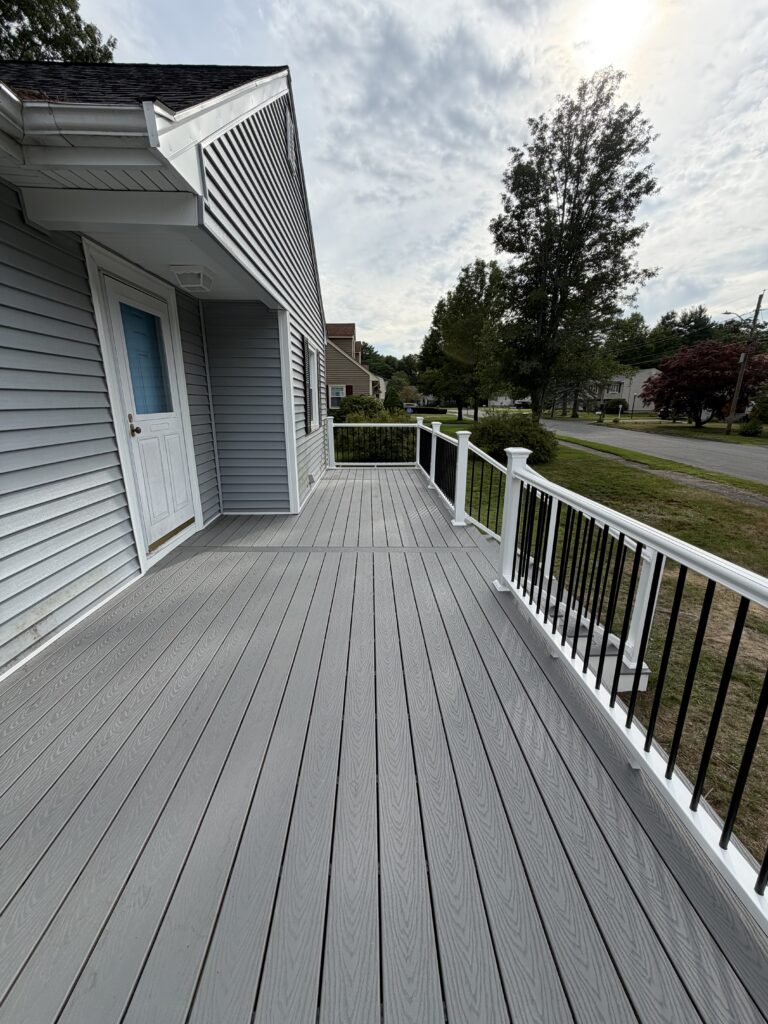 Composite deck boards with white vinyl railing installed by J&J All Seasons Corp
