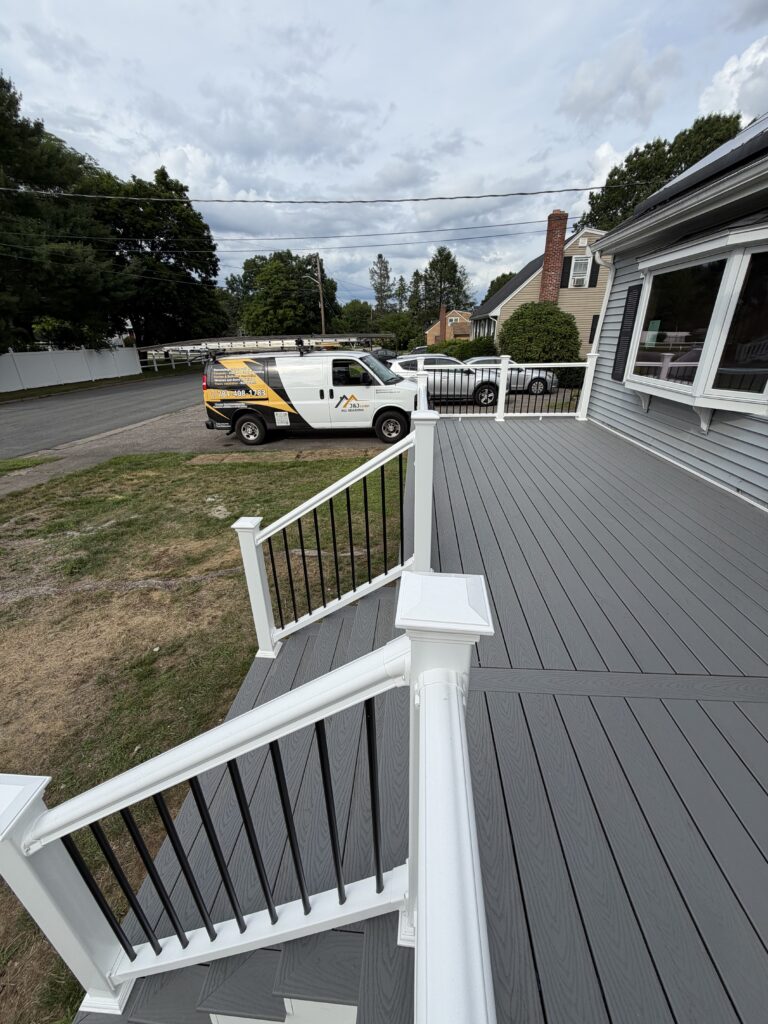 New composite deck with white railings in Stoughton, MA by J&J All Seasons Corp